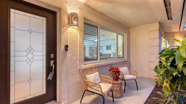 doorway to property featuring a porch and stucco siding