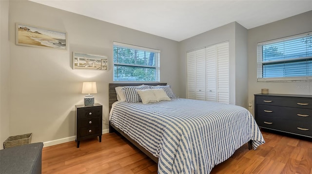 bedroom featuring a closet, wood finished floors, and baseboards