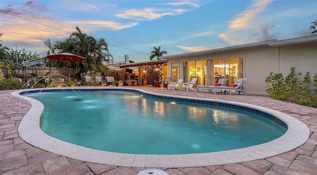 pool at dusk with a fenced in pool, a patio, and fence