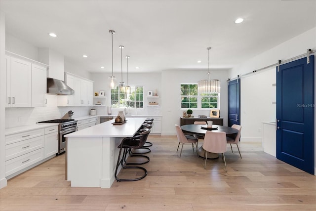 kitchen featuring white cabinets, a center island, a barn door, and stainless steel appliances