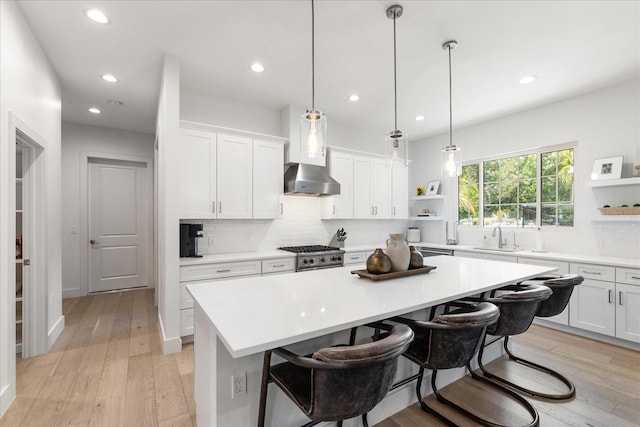 kitchen with decorative light fixtures, a kitchen island, white cabinetry, and a breakfast bar area