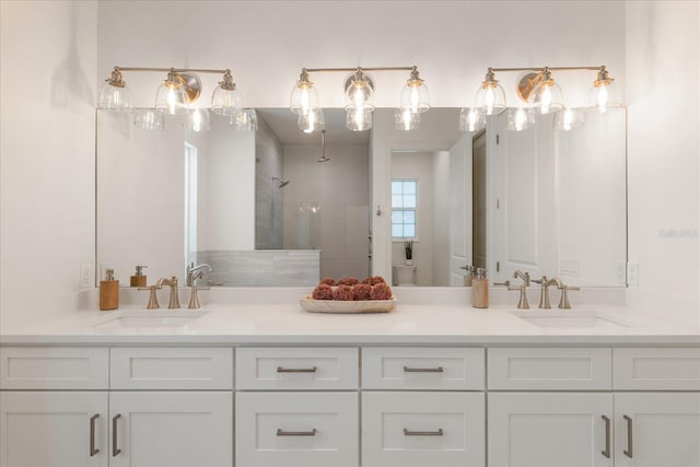 bathroom with vanity, toilet, and tiled shower