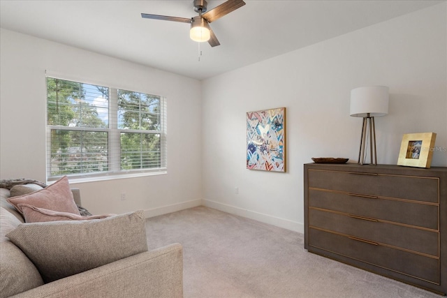 living area with ceiling fan and light colored carpet