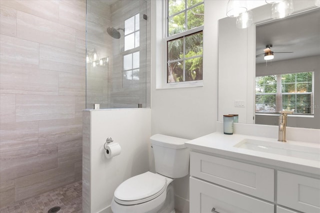 bathroom featuring plenty of natural light, a tile shower, and vanity