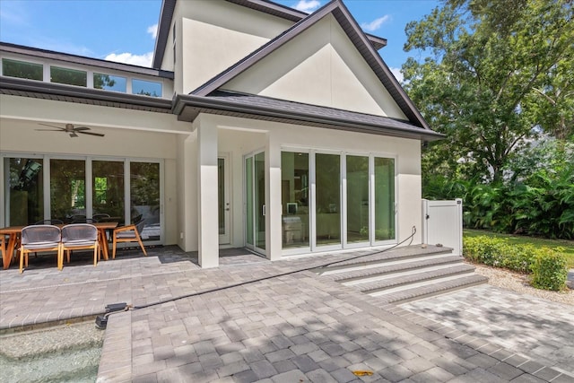 rear view of house with ceiling fan and a patio area