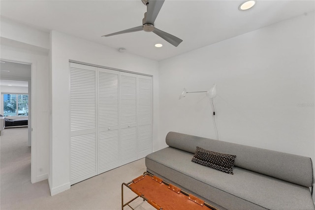 sitting room featuring light carpet and ceiling fan