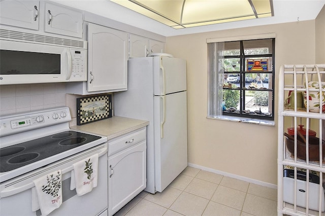 kitchen with white cabinets, white appliances, and light tile patterned floors