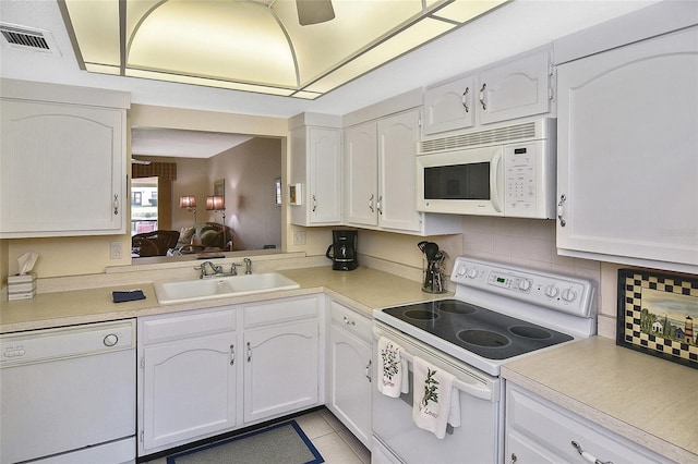 kitchen featuring white cabinets, light tile patterned floors, white appliances, and sink