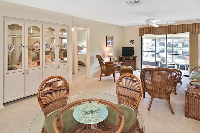 carpeted dining room featuring ceiling fan