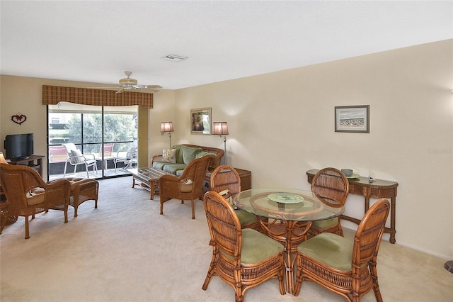 carpeted dining space with ceiling fan