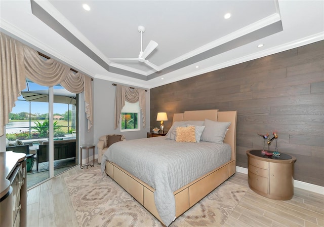 bedroom with a tray ceiling, access to exterior, and ornamental molding