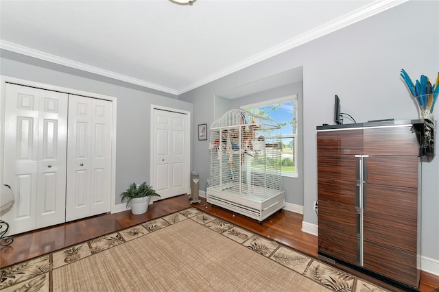 foyer with hardwood / wood-style flooring and crown molding