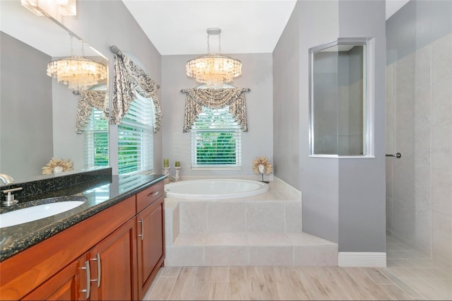 bathroom with hardwood / wood-style flooring, vanity, a chandelier, and independent shower and bath