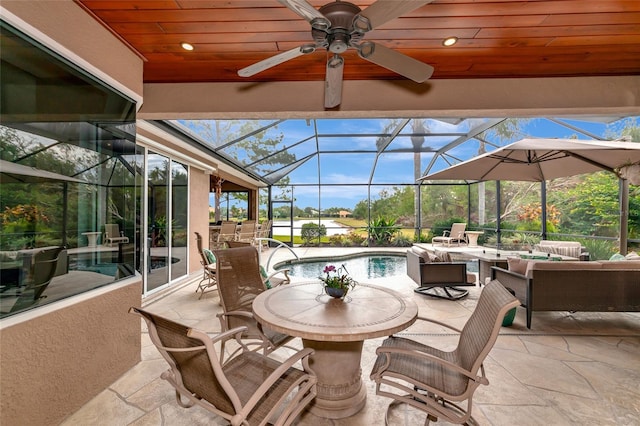 view of patio / terrace with an outdoor living space, glass enclosure, and ceiling fan