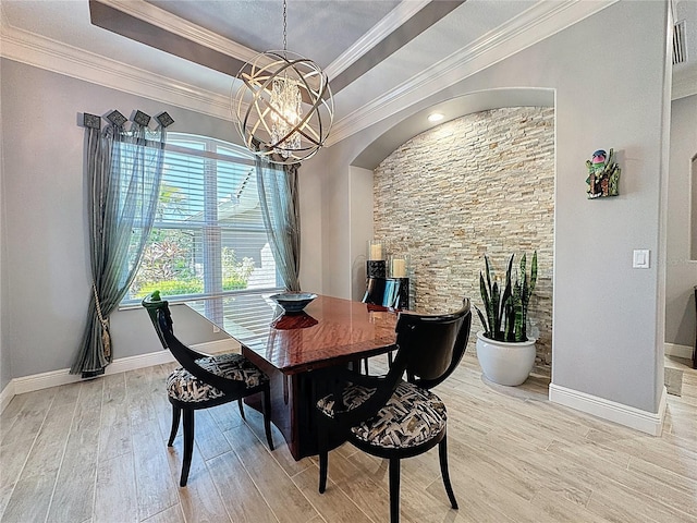 dining room with crown molding, an inviting chandelier, light wood-style floors, baseboards, and a tray ceiling