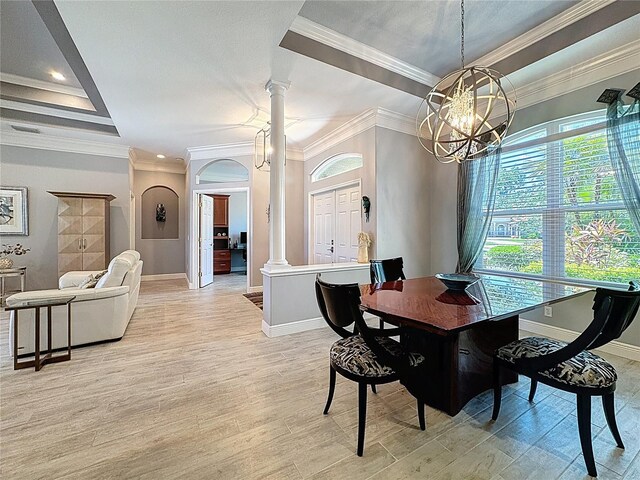 dining room with baseboards, decorative columns, a raised ceiling, and light wood-style floors