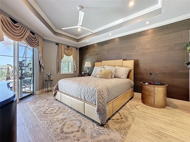 bedroom with ornamental molding, wood finished floors, wooden walls, and access to exterior
