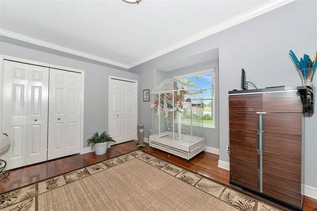 bedroom featuring baseboards, ornamental molding, and wood finished floors