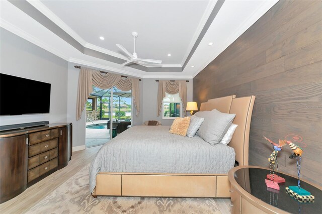 bedroom with crown molding, light wood-style floors, access to outside, recessed lighting, and a tray ceiling
