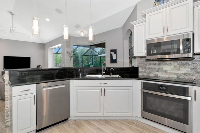 kitchen with visible vents, decorative backsplash, white cabinetry, a sink, and appliances with stainless steel finishes