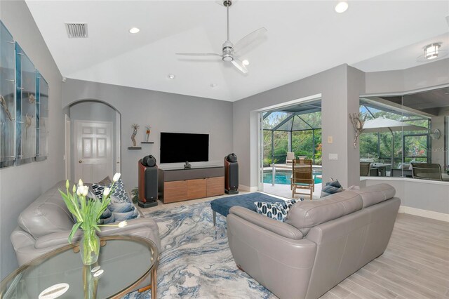 living area featuring a sunroom, a ceiling fan, vaulted ceiling, light wood-type flooring, and visible vents