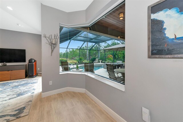 interior space with a sunroom, recessed lighting, baseboards, and wood finished floors