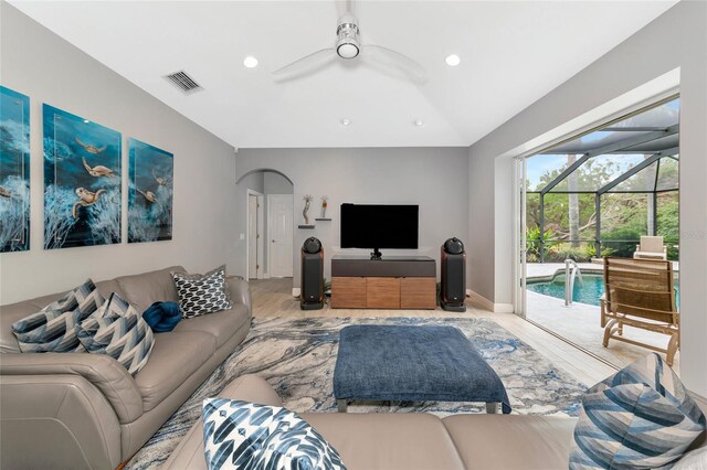 living area featuring ceiling fan, a sunroom, wood finished floors, vaulted ceiling, and visible vents