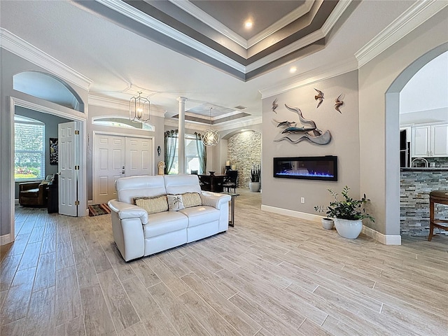 16806 5th Ter NE, Bradenton, FL 34212 - living area featuring arched walkways, a tray ceiling, light wood-style floors, crown molding, and a chandelier