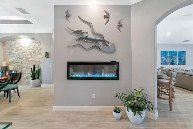 16806 5th Ter NE, Bradenton, FL 34212 - living room with arched walkways, a glass covered fireplace, baseboards, wood finished floors, and ornamental molding