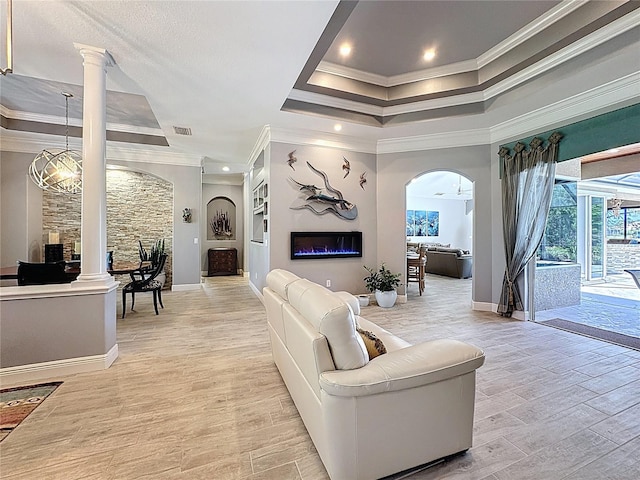 16806 5th Ter NE, Bradenton, FL 34212 - living area featuring crown molding, a tray ceiling, arched walkways, decorative columns, and light wood-style floors