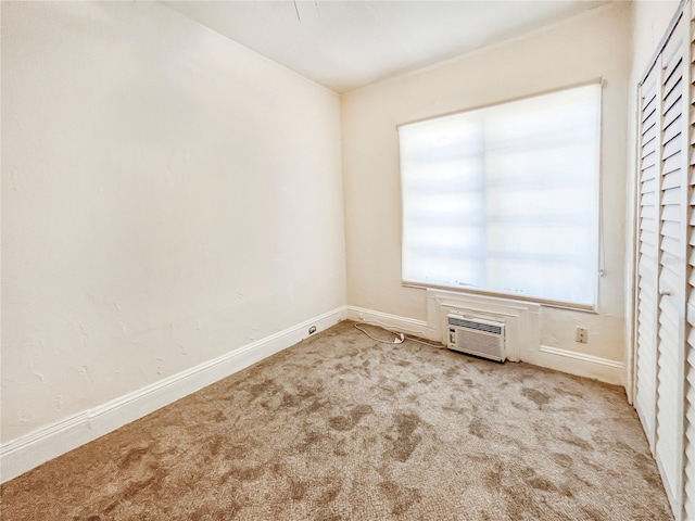 unfurnished bedroom featuring light carpet and a wall unit AC