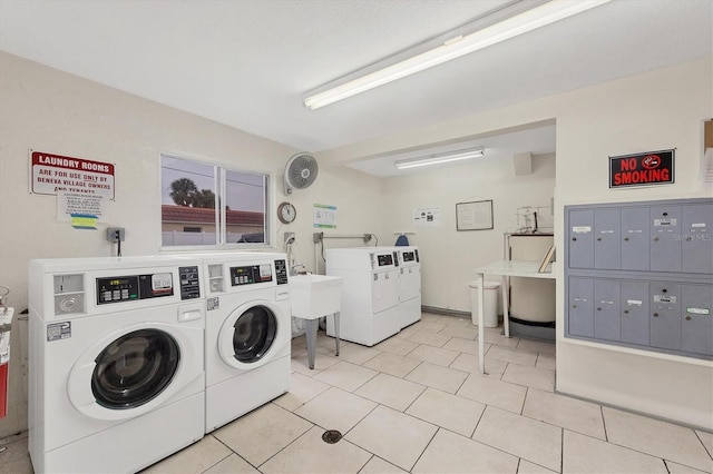 laundry area with independent washer and dryer, sink, light tile patterned floors, and a mail area