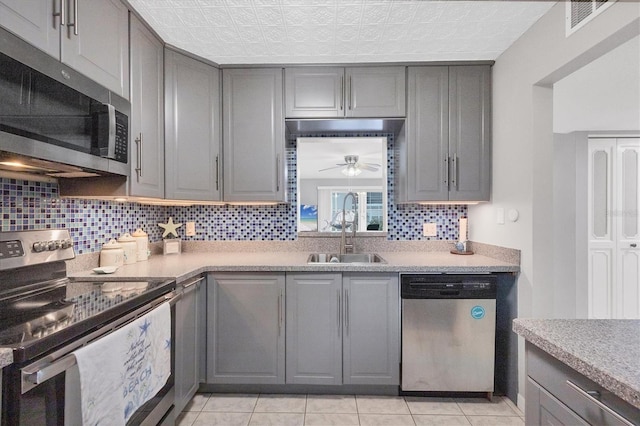 kitchen with gray cabinetry, sink, and appliances with stainless steel finishes