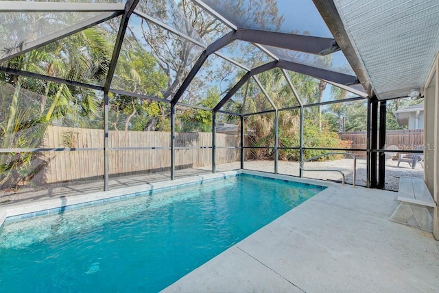 view of pool with glass enclosure and a patio