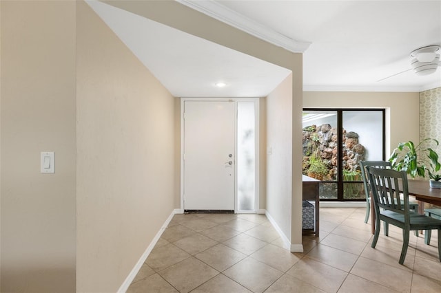 entryway with light tile patterned floors and ornamental molding