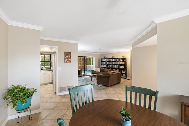 dining area with light tile patterned floors and crown molding