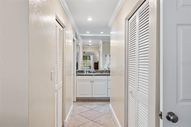 hallway with crown molding, light tile patterned flooring, and sink