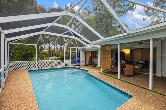 view of swimming pool featuring ceiling fan, a lanai, and a patio area