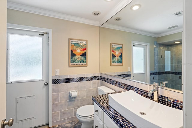 bathroom featuring tile walls, toilet, vanity, walk in shower, and crown molding