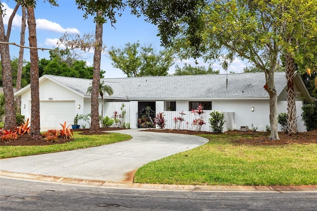 ranch-style house with a garage and a front lawn