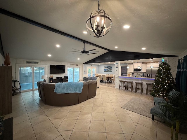 living room with ceiling fan with notable chandelier, a textured ceiling, vaulted ceiling with beams, and light tile patterned flooring