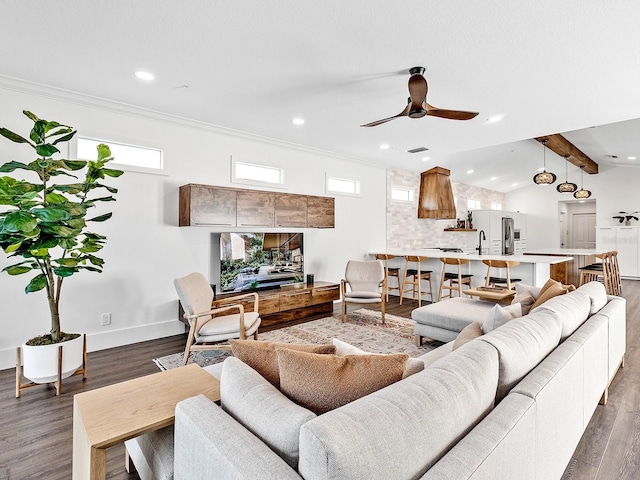 living room featuring sink, lofted ceiling with beams, ornamental molding, dark hardwood / wood-style flooring, and ceiling fan