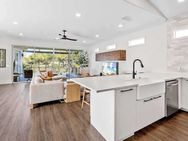 kitchen featuring backsplash, kitchen peninsula, sink, and white cabinets