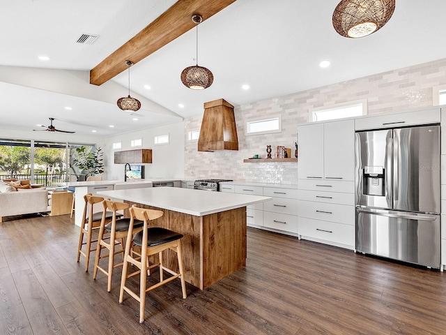 kitchen with white cabinetry, decorative light fixtures, appliances with stainless steel finishes, dark hardwood / wood-style floors, and a kitchen island