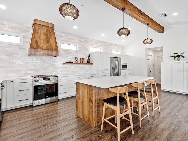 kitchen featuring white cabinetry, appliances with stainless steel finishes, decorative light fixtures, and custom range hood