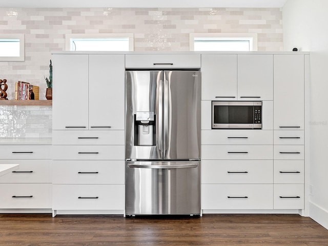 kitchen with dark wood-type flooring, white cabinets, and appliances with stainless steel finishes