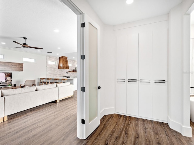 corridor with sink and hardwood / wood-style floors