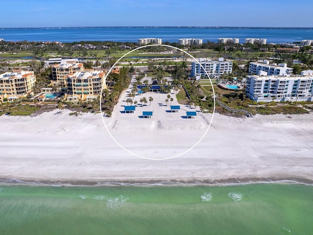 bird's eye view with a water view and a beach view