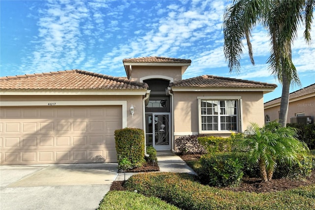 mediterranean / spanish-style home with a garage and central AC unit