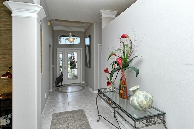 tiled entrance foyer with ornate columns and crown molding